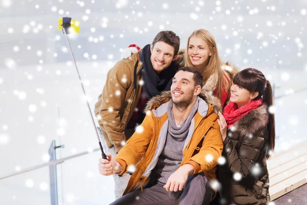 Amigos felices con smartphone en pista de patinaje —  Fotos de Stock