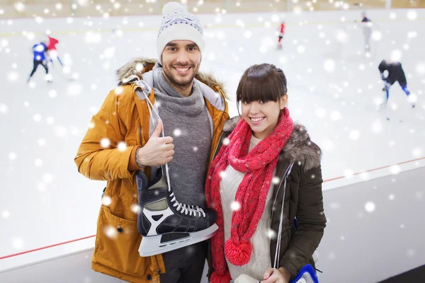 Glückliches Paar mit Schlittschuhen auf Eisbahn — Stockfoto