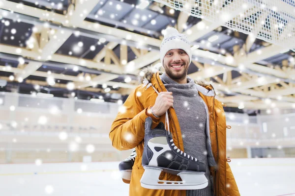 Heureux jeune homme avec patins à glace sur patinoire — Photo