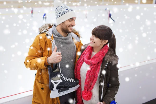 Couple heureux avec patins à glace sur patinoire — Photo