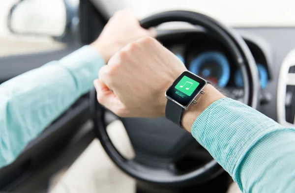 Mãos com ícone de música no carro de condução smartwatch — Fotografia de Stock