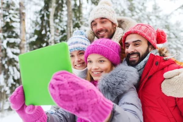 Amigos sonrientes con la tableta PC en el bosque de invierno —  Fotos de Stock