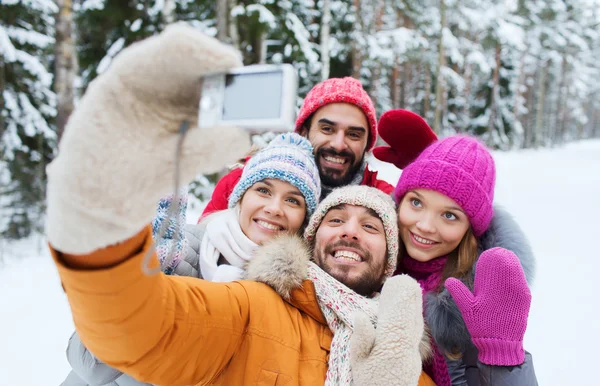 Amigos sonrientes con cámara en el bosque de invierno —  Fotos de Stock