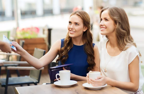 Mulheres que pagam dinheiro para garçom para o café no café — Fotografia de Stock