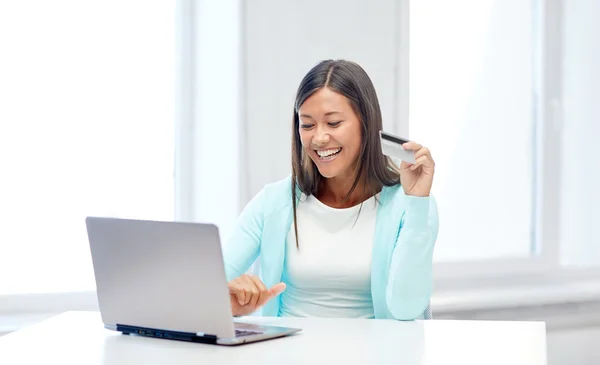 Mujer sonriente con computadora portátil y tarjeta de crédito — Foto de Stock