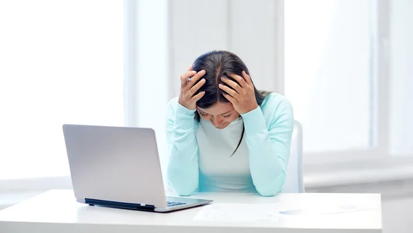 Empresária com laptop e papéis no escritório — Fotografia de Stock