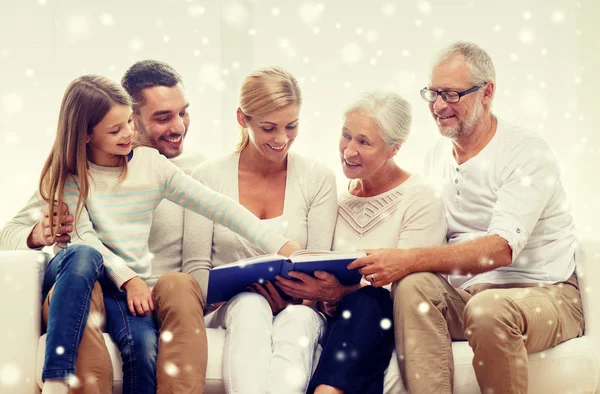 Famille heureuse avec livre ou album photo à la maison — Photo