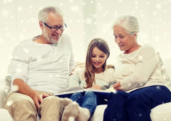 Famille souriante avec livre à la maison — Photo