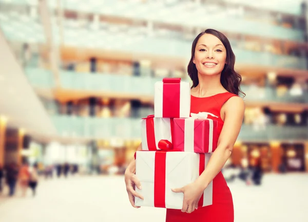Mulher sorridente em vestido vermelho com caixa de presente — Fotografia de Stock