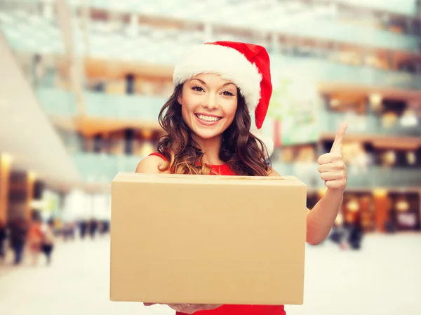 Mujer sonriente en sombrero de ayudante de santa con caja de paquete —  Fotos de Stock