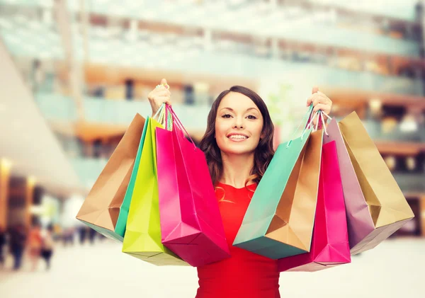 Femme souriante avec des sacs à provisions colorés — Photo