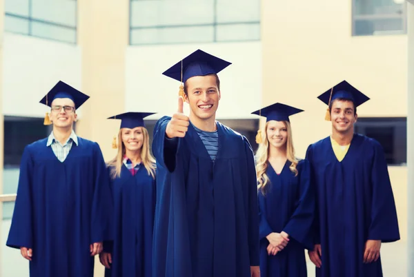 Grup gülümseyen öğrenci mortarboards içinde — Stok fotoğraf