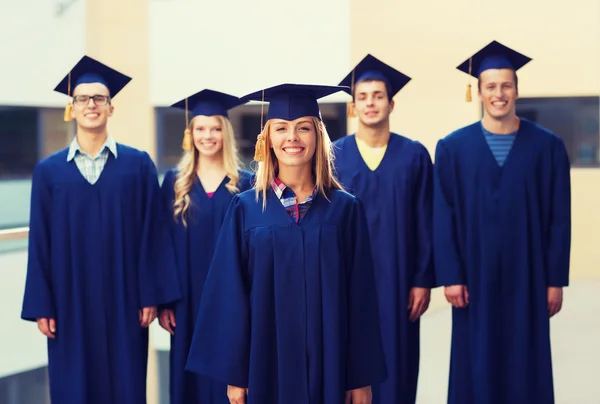 Grupa uśmiechający się uczniów w mortarboards — Zdjęcie stockowe