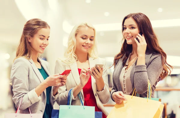 Boldog nők okostelefonok és a bevásárló szatyrok — Stock Fotó