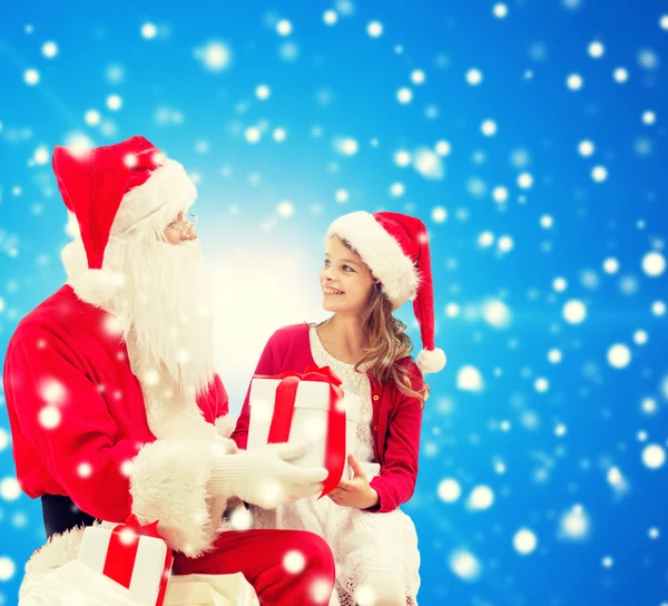 Petite fille souriante avec santa claus et cadeaux — Photo