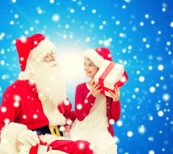 Usměvavá holčička s santa claus a dary — Stock fotografie