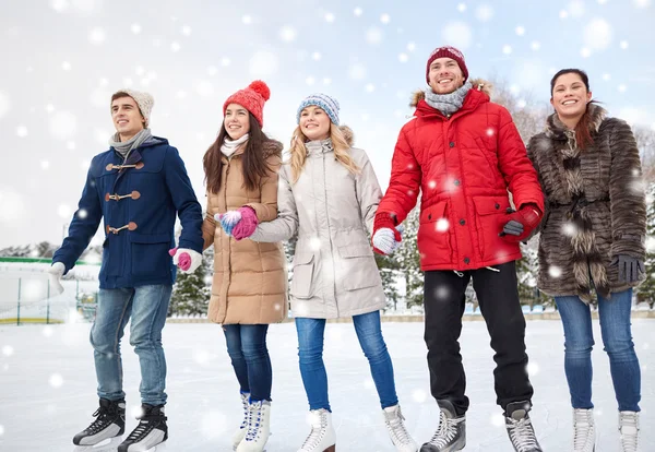 Happy přátelé bruslení na kluzišti venku — Stock fotografie