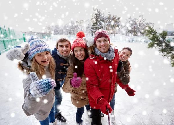 Amis heureux avec smartphone sur patinoire — Photo