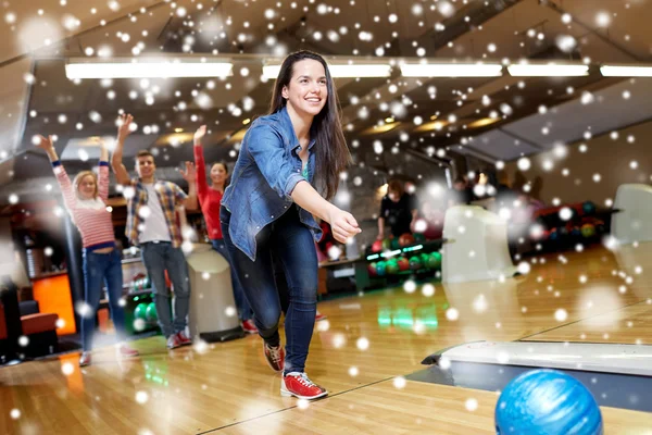 Šťastná mladá žena házení míče v bowling Clubu — Stock fotografie