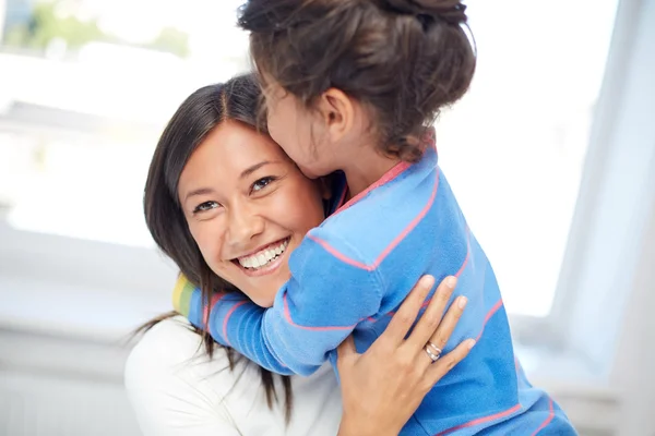 happy mother and daughter hugging at home