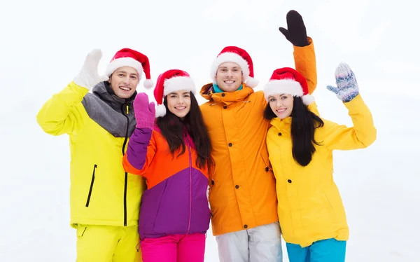 Amici felici in cappelli di Babbo Natale e tute da sci all'aperto — Foto Stock