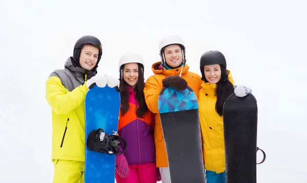 Happy vrienden in helmen met snowboards buitenshuis — Stockfoto