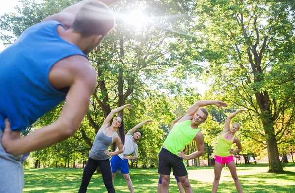 Grupo de amigos o deportistas que hacen ejercicio al aire libre — Foto de Stock