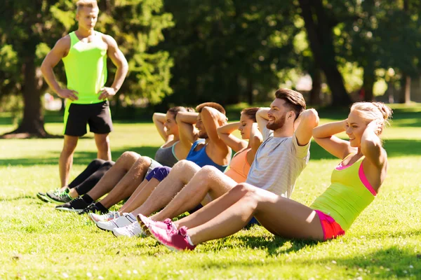 Grupo de amigos o deportistas que hacen ejercicio al aire libre — Foto de Stock