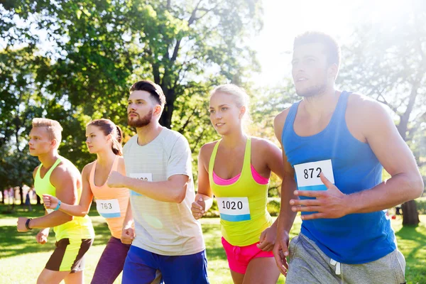 Feliz joven deportistas carreras ingenio insignia números — Foto de Stock