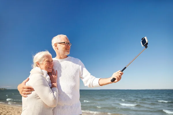 Senioren met smartphone selfie nemen op strand — Stockfoto