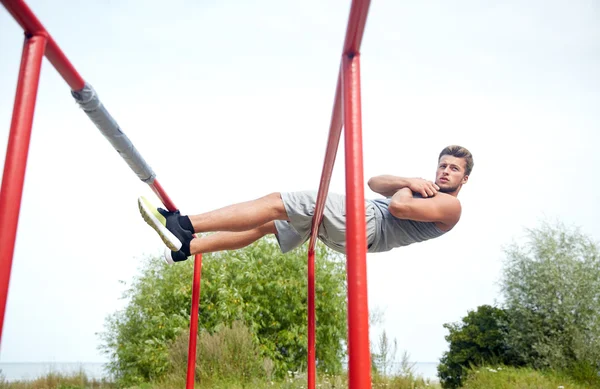 Joven haciendo sentarse en paralelo bares al aire libre —  Fotos de Stock