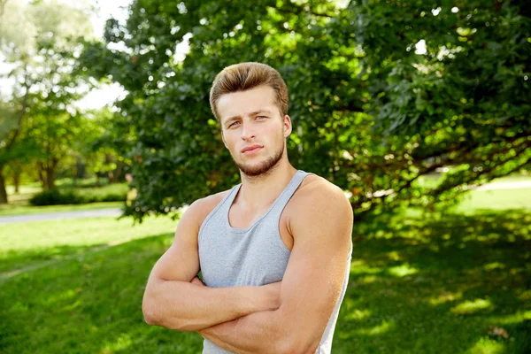 Sporty young man with crossed arms at summer park — Stock Photo, Image