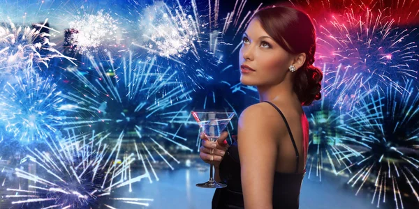 Woman holding cocktail over firework in city Stockfoto
