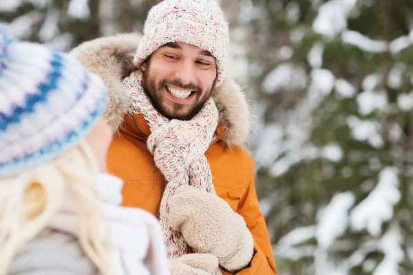 Happy friends or couple in winter forest Royalty Free Stock Images