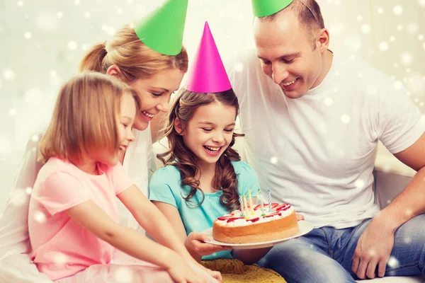 Familia feliz con dos niños en sombreros de fiesta en casa —  Fotos de Stock