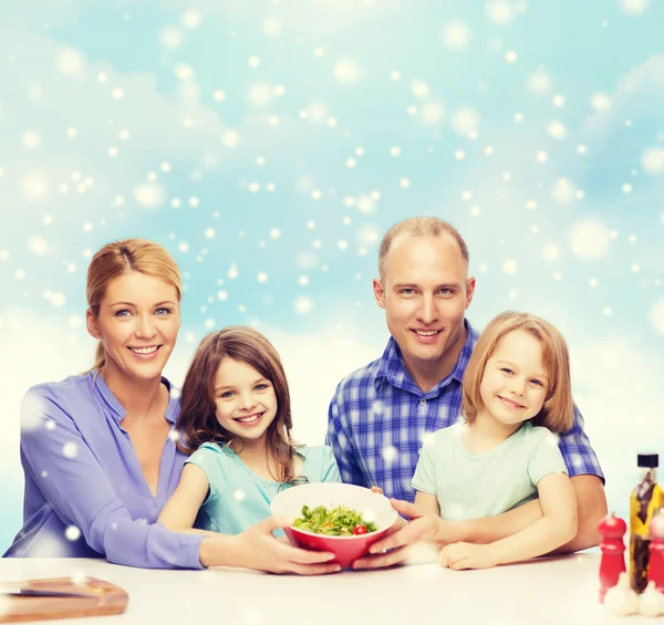 Счастливая семья с двумя детьми, показывающая салат в миске — стоковое фото