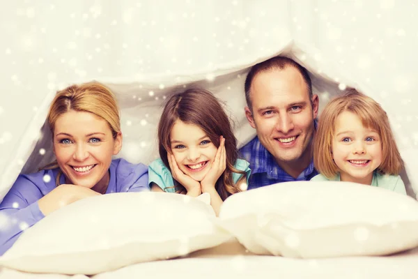 Famille heureuse avec deux enfants sous couverture à la maison — Photo