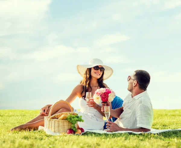 Sonriente pareja bebiendo champán en el picnic —  Fotos de Stock