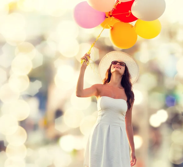Sorridente giovane donna in occhiali da sole con palloncini — Foto Stock