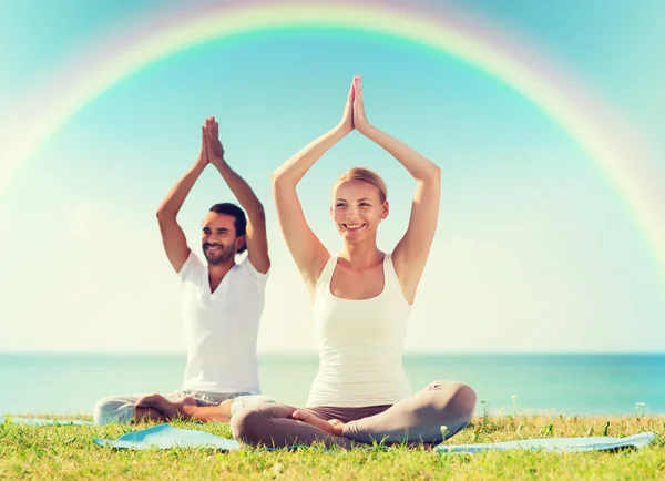 Glimlachend paar oefeningen maken yoga buiten — Stockfoto