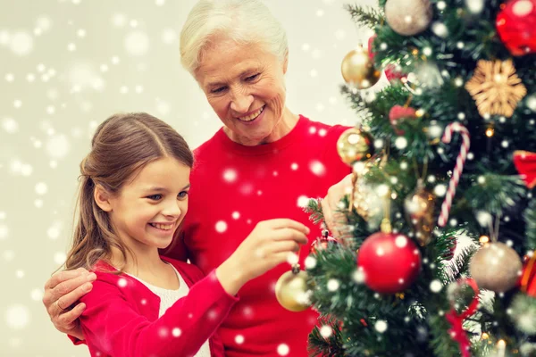 Lächelnde Familie schmückt Weihnachtsbaum zu Hause — Stockfoto