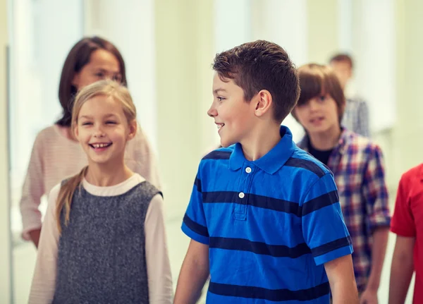 Groupe d'écoliers souriants marchant dans le couloir — Photo