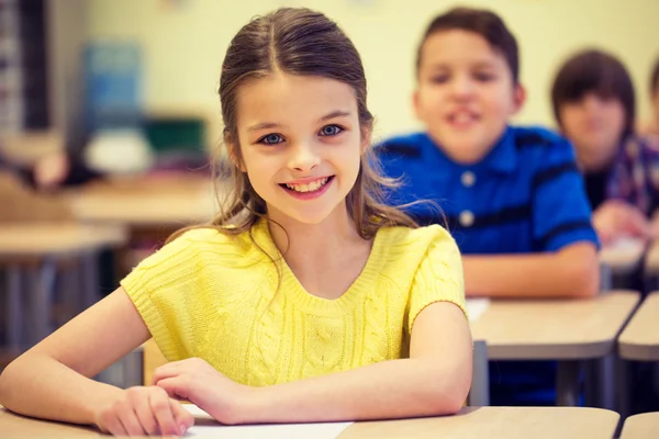 Group of school kids with notebooks in classroom — Stock Photo, Image