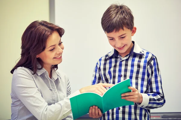 Schüler mit Notizbuch und Lehrer im Klassenzimmer — Stockfoto