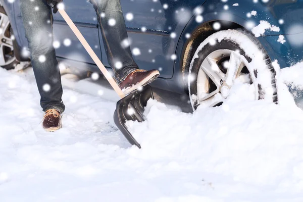 Primo piano dell'uomo che scava neve con pala vicino all'auto — Foto Stock