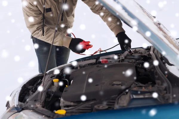 Nahaufnahme eines Mannes unter Motorhaube mit Starterkabel — Stockfoto