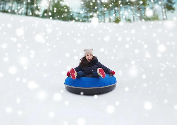 Menina adolescente feliz deslizando para baixo no tubo de neve — Fotografia de Stock