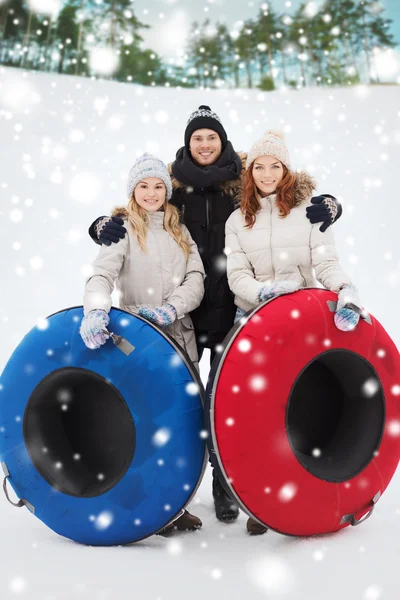 Groep lachende vrienden met sneeuw buizen — Stockfoto