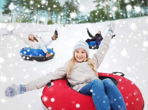 Group of happy friends sliding down on snow tubes — Stock Photo, Image