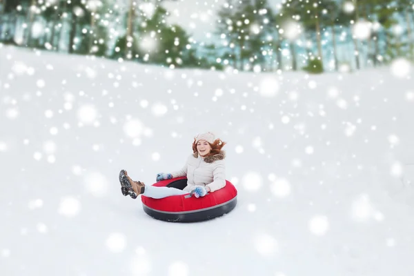 Menina adolescente feliz deslizando para baixo no tubo de neve — Fotografia de Stock